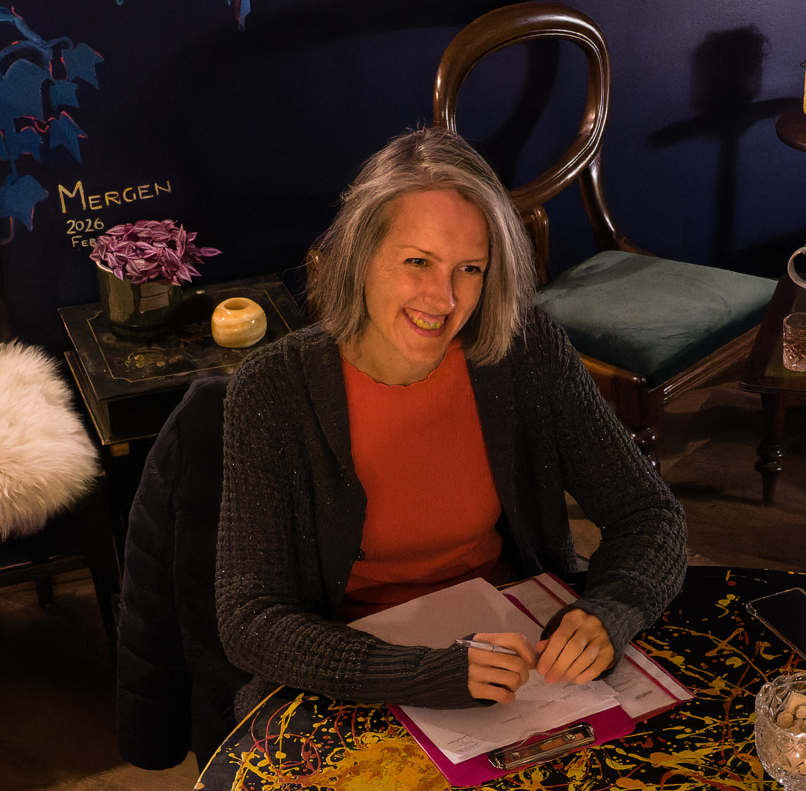 Maria Depker sitzt am Tisch in einem Café und hält den InnerGrowth Workshop in Berlin.